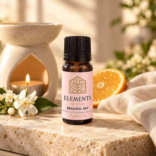 Beautiful Day fragrance oil 10ml bottle beside a lit ceramic oil burner – Elements of Fragrance