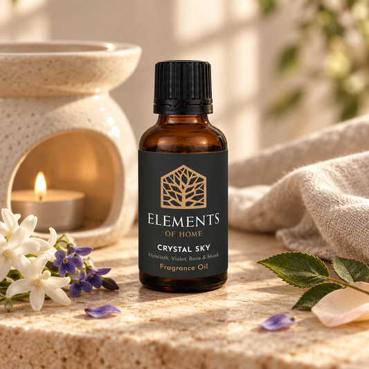 Crystal Sky 30ml fragrance oil beside a lit ceramic oil burner – Elements of Fragrance