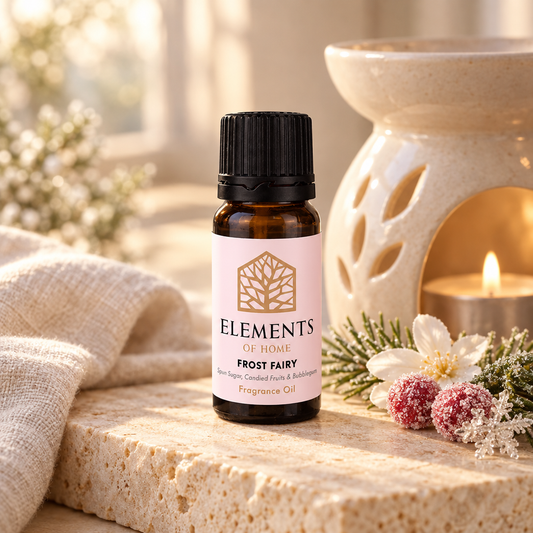 Frost Fairy fragrance oil 10ml bottle beside a lit ceramic oil burner – Elements of Fragrance