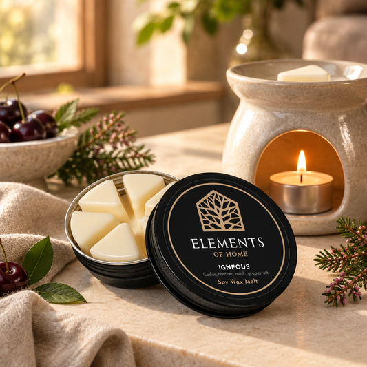 Igneous 50g soy wax melt in a black tin beside a lit ceramic wax burner – Elements of Fragrance