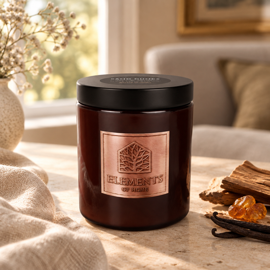 Sand Dunes 140g luxury candle in an amber glass jar in a cosy living room – Elements of Fragrance