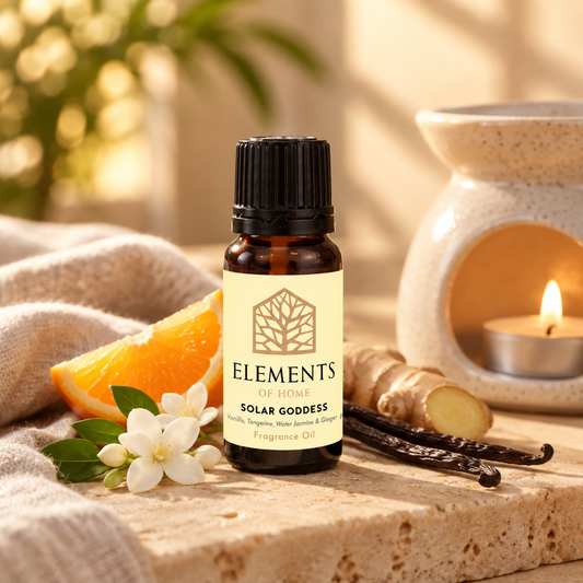 Solar Goddess fragrance oil 10ml bottle beside a lit ceramic oil burner – Elements of Fragrance