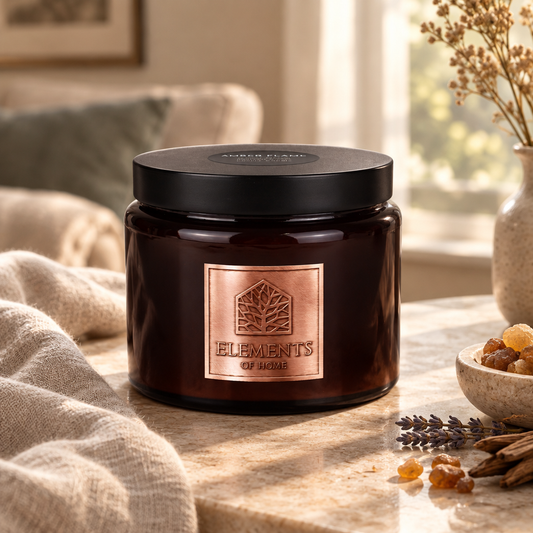 Amber Flame 413g luxury candle in an amber glass jar in a cosy living room – Elements of Fragrance