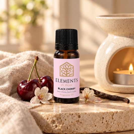 Black Cherry fragrance oil 10ml bottle beside a lit ceramic oil burner – Elements of Fragrance