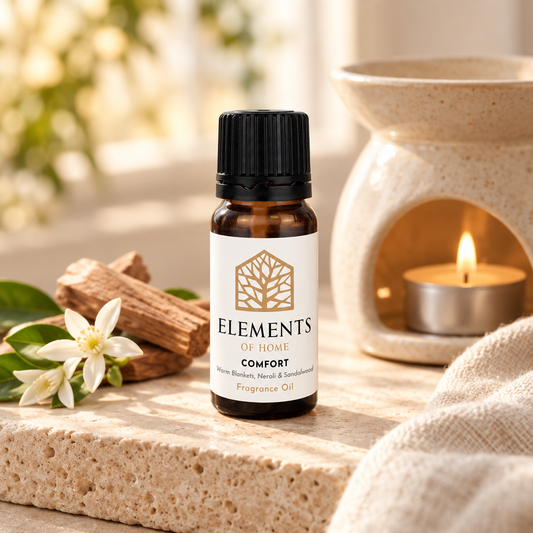 Comfort fragrance oil 10ml bottle beside a lit ceramic oil burner – Elements of Fragrance