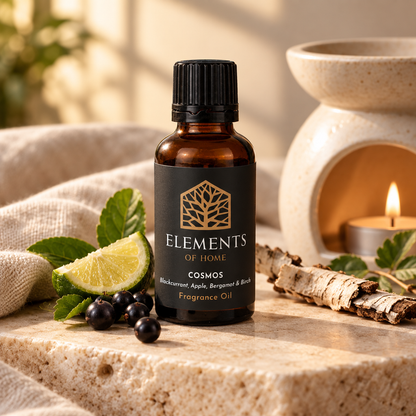Cosmos 30ml fragrance oil beside a lit ceramic oil burner – Elements of Fragrance