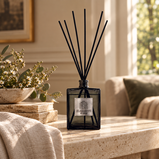 Cosmos 500ml luxury reed diffuser in a black glass bottle styled in a sunlit living room – Elements of Fragrance