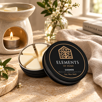 Cosmos 50g soy wax melt in a black tin beside a lit ceramic wax burner – Elements of Fragrance
