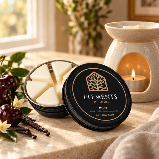 Dusk 50g soy wax melt in a black tin beside a lit ceramic wax burner – Elements of Fragrance