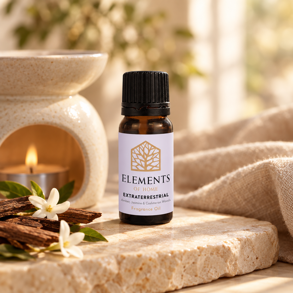 Extraterrestrial fragrance oil 10ml bottle beside a lit ceramic oil burner – Elements of Fragrance
