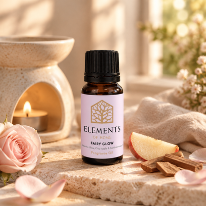 Fairy Glow fragrance oil 10ml bottle beside a lit ceramic oil burner – Elements of Fragrance