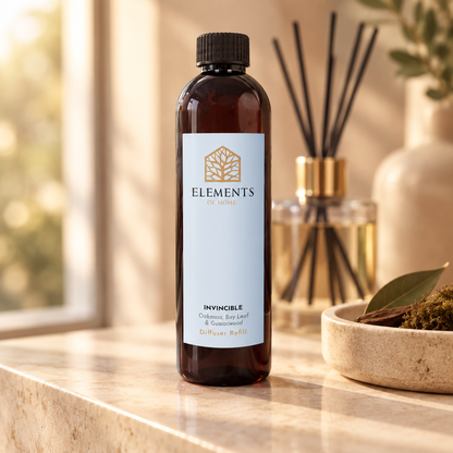 Invincible reed diffuser refill bottle beside a reed diffuser – Elements of Fragrance