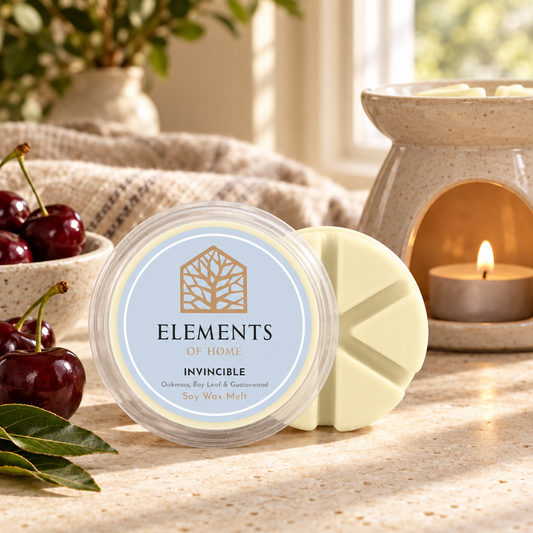 Invincible 50g soy wax melt snap pot beside a lit ceramic wax burner – Elements of Fragrance