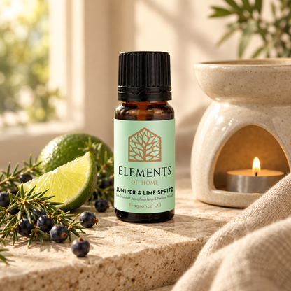 Juniper & Lime Spritz fragrance oil 10ml bottle beside a lit ceramic oil burner – Elements of Fragrance