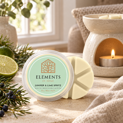 Juniper & Lime Spritz 50g soy wax melt snap pot beside a lit ceramic wax burner – Elements of Fragrance