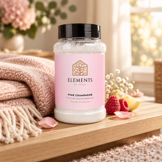 Pink Champagne scented carpet sprinkles shaker tub on a wooden shelf with cosy throws – Elements of Fragrance