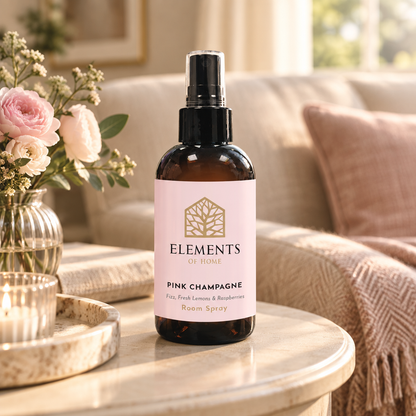Pink Champagne room spray on a side table in a sunlit living room – Elements of Fragrance