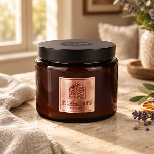 Sand Dunes 413g luxury candle in an amber glass jar in a cosy living room – Elements of Fragrance