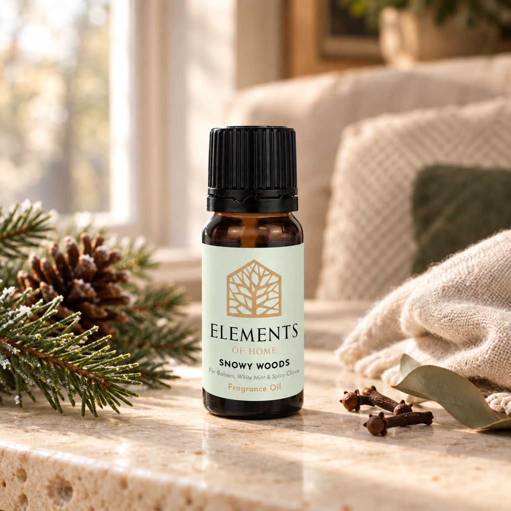 Snowy Woods fragrance oil 10ml bottle beside a lit ceramic oil burner – Elements of Fragrance