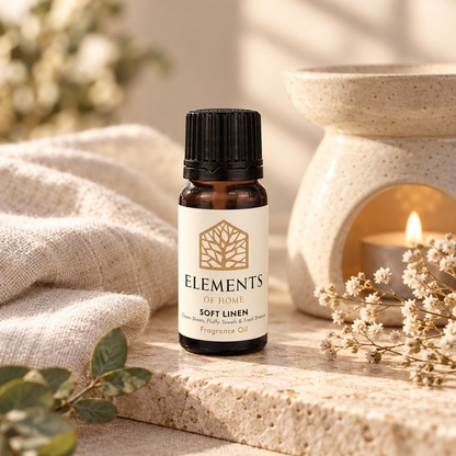 Soft Linen fragrance oil 10ml bottle beside a lit ceramic oil burner – Elements of Fragrance