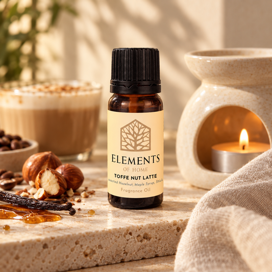 Toffee Nut Latte fragrance oil 10ml bottle beside a lit ceramic oil burner – Elements of Fragrance