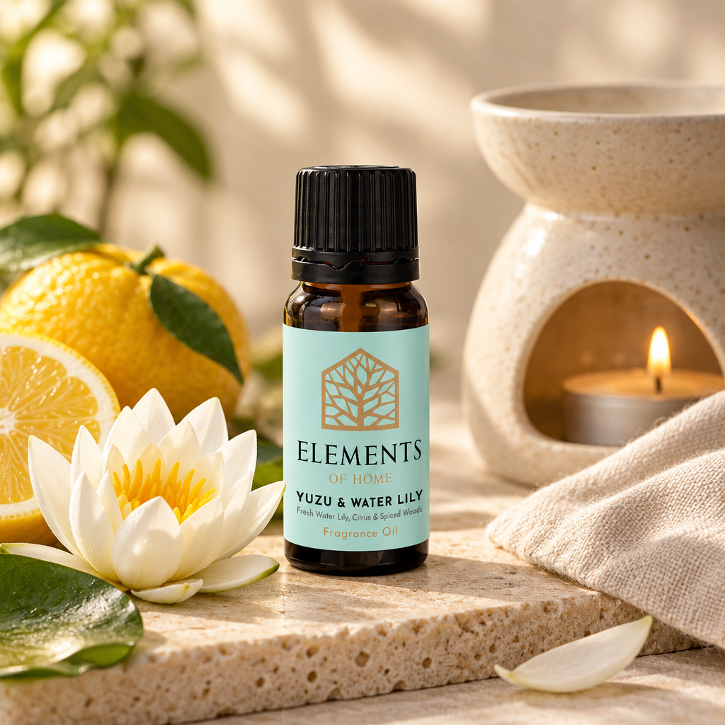 Yuzu & Waterlily fragrance oil 10ml bottle beside a lit ceramic oil burner – Elements of Fragrance