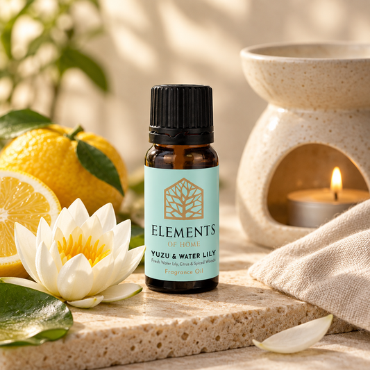 Yuzu & Waterlily fragrance oil 10ml bottle beside a lit ceramic oil burner – Elements of Fragrance